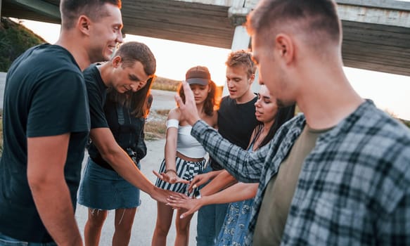 Talking and laughing. Group of young cheerful friends having fun together. Party outdoors.