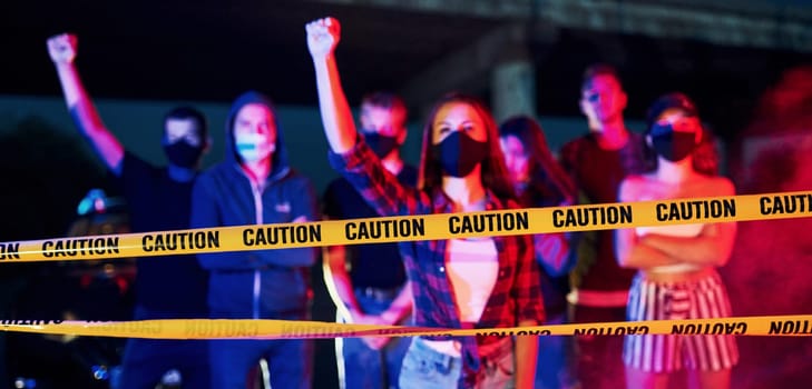 Police line and smoke. Group of protesting young people that standing together. Activist for human rights or against government.