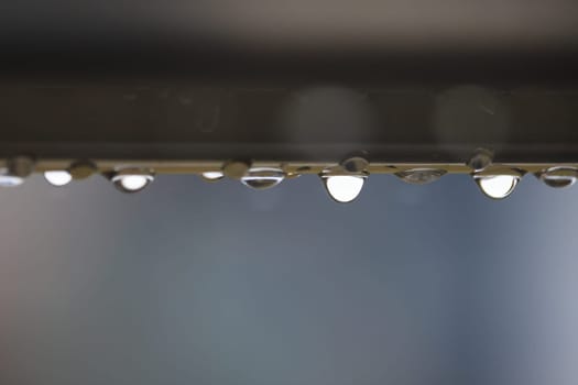 Closeup Water Drops Dripping from Underside of Pipe. High quality photo