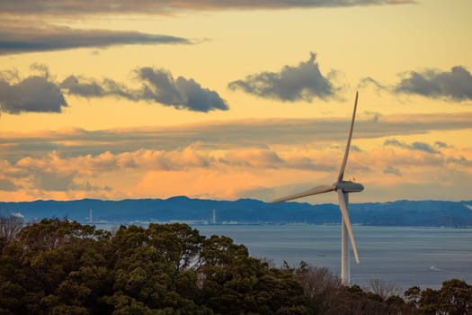 Coastal Wind Turbine with Beautiful Sunset Sky in Background. High quality photo