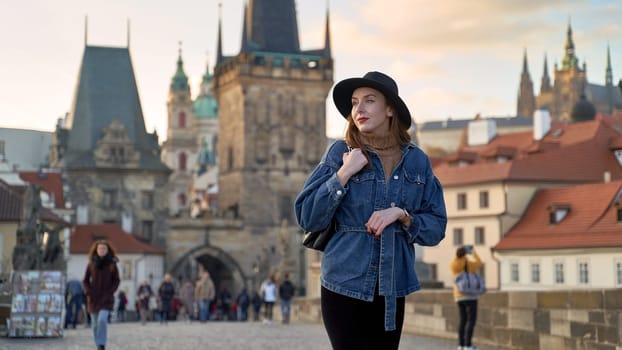 Stylish young beautiful woman earing black hat in Prague on background. Elegant retro lady fine art portrait.