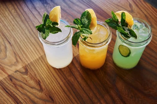 Yellow and green colored. Close up view of fresh summer alcoholic cocktails on the wooden table.