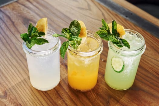 Yellow and green colored. Close up view of fresh summer alcoholic cocktails on the wooden table.