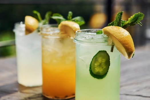 Yellow and green colored. Close up view of fresh summer alcoholic cocktails on the wooden table.