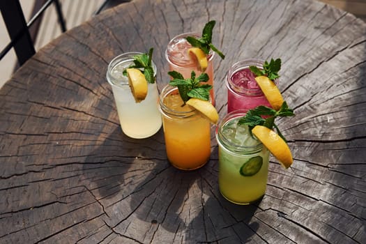 Yellow and green colored. Close up view of fresh summer alcoholic cocktails on the wooden table.