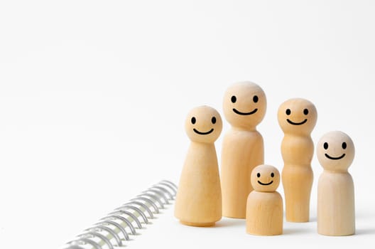 Happy face on wooden figures of family members. Emotion and satisfaction family concepts.