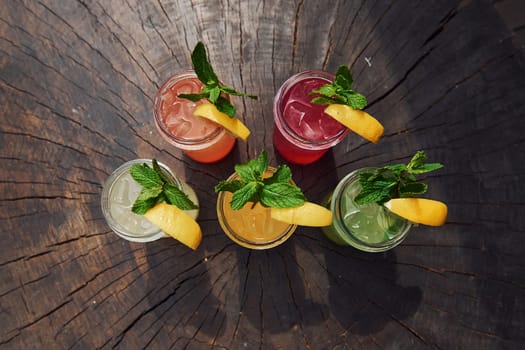 Yellow and green colored. Close up view of fresh summer alcoholic cocktails on the wooden table.