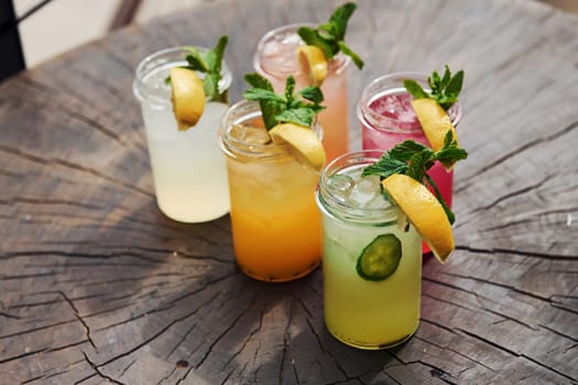 Yellow and green colored. Close up view of fresh summer alcoholic cocktails on the wooden table.