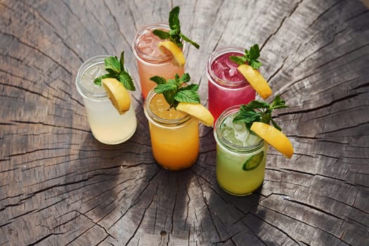 Yellow and green colored. Close up view of fresh summer alcoholic cocktails on the wooden table.