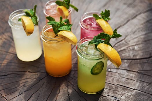 Yellow and green colored. Close up view of fresh summer alcoholic cocktails on the wooden table.