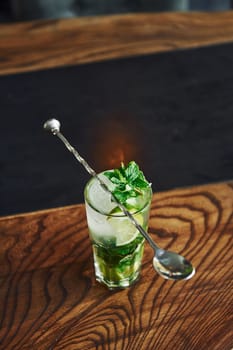 Close up view of fresh summer non alcoholic mojito cocktail on the wooden table.