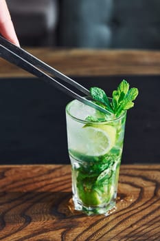 Close up view of fresh summer non alcoholic mojito cocktail on the wooden table.