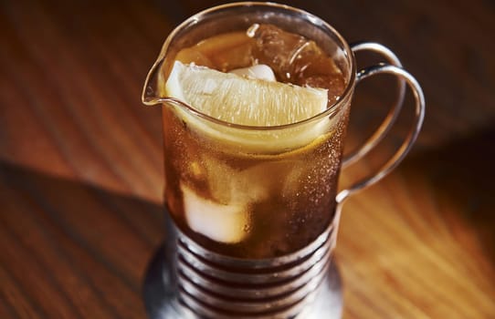 Ice cubes inside. Close up view of fresh summer cocktail on the wooden table.