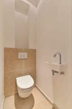 a toilet in the corner of a room with tile flooring and beige tiles on the walls, there is a mirror above it