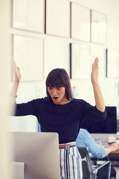 When technology attacks. a young businesswoman using a computer and looking stressed out at her desk in a modern office