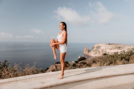 Fitness woman sea. Outdoor workout on yoga mat in park near to ocean beach. Female fitness pilates yoga routine concept. Healthy lifestyle. Happy fit woman exercising with rubber band in park.