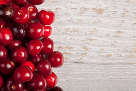 Cherries on wooden table with text space available. Raw fresh healthy lifestyle