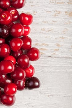 Fresh cherries on white wooden table. Raw healthy fruits