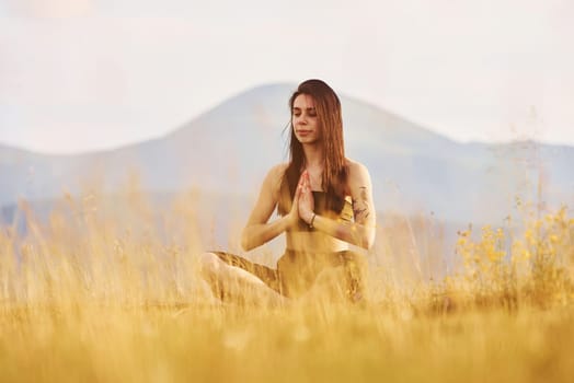 Beautiful young woman doing yoga exercises. Majestic Carpathian Mountains. Beautiful landscape of untouched nature.