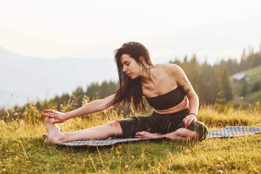 Beautiful young woman doing yoga exercises. Majestic Carpathian Mountains. Beautiful landscape of untouched nature.