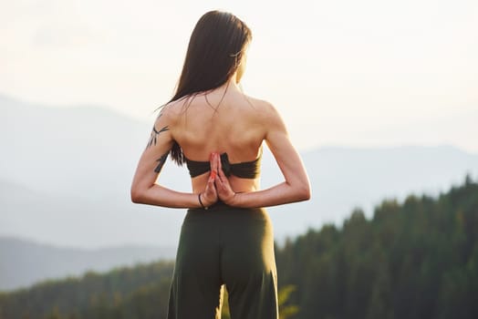 Beautiful young woman doing yoga exercises. Majestic Carpathian Mountains. Beautiful landscape of untouched nature.