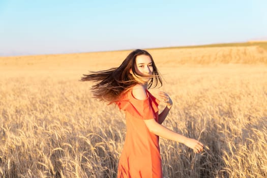 Young woman in the wheat field. Look back. Finding inner balance concept. Copy space