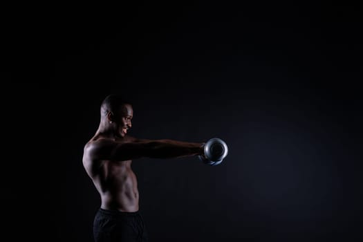 One young african muscular build man standing topless silhouette isolated on a black background