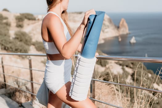 Fitness woman sea. Outdoor workout on yoga mat in park near to ocean beach. Female fitness pilates yoga routine concept. Healthy lifestyle. Happy fit woman exercising with rubber band in park.
