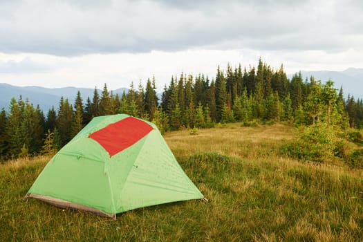 Red flag on the tent. Majestic Carpathian Mountains. Beautiful landscape of untouched nature.
