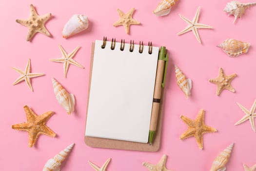 blank note book with starfish or seashells on a pink background , summer vaction concept.