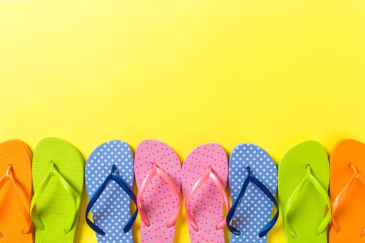 a lot of flip flop colored sandals, summer vacation on colored background, copy space top view.