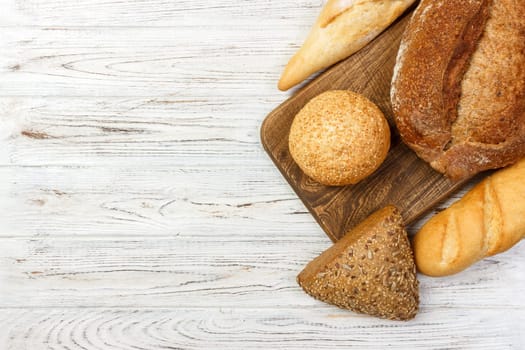 assortment of baked bread on wood table. top view with copy space.