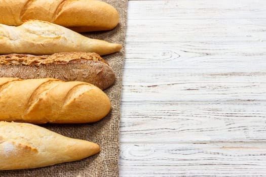 different types of baguette on a wooden background.