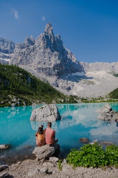 Couple of men and women visiting Lago di Sorapis in the Italian Dolomites, milky blue lake Lago di Sorapis, Lake Sorapis, Dolomites, Italy.