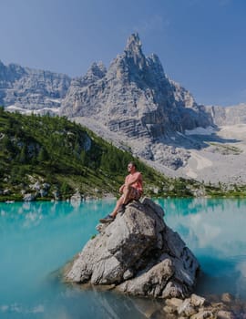 men visiting Lago di Sorapis in the Italian Dolomites, milky blue lake Lago di Sorapis, Lake Sorapis, Dolomites, Italy.