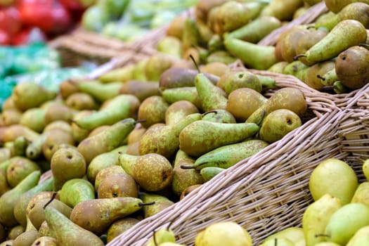 Shelves with natural fruits pears in supermarket or farmer market. Fresh food. Selective focus