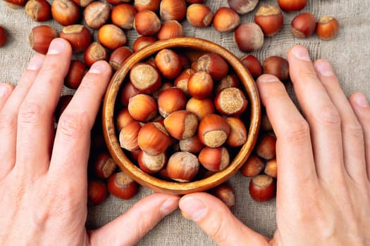 Whole raw hazelnuts on a linen napkin background. Paleo diet baking cooking concept. Selective focus