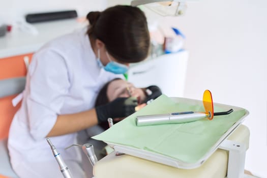 Equipment for dentistry UV ultraviolet lamp in dentist office, background patient in dental chair and attending doctor