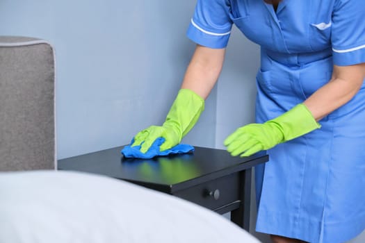 Cleaning service, woman in uniform with gloves with rag clean room, apartment cleaning