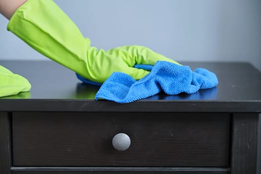 Cleaning service, close-up of gloved hands with microfiber cloth wiping dust, apartment cleaning