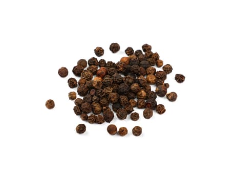 Close up heap of black pepper peppercorns spilled and spread around isolated on white background, high angle view