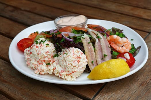 Close up large cold and smoked seafood platter on wooden table, high angle view