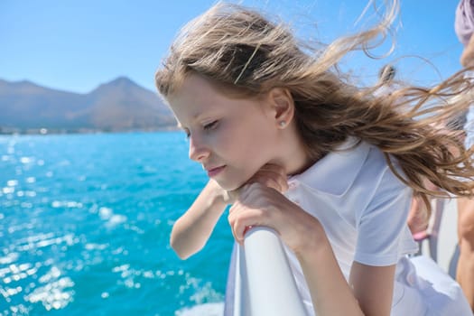 Beautiful little girl child blond enjoying sea voyage, sunny summer day, picturesque landscapes on horizon, copy space. Boat trip on small ship on Greek bay of Mirabello