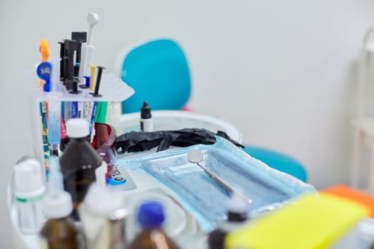 Kyiv UA, 31-07-2019. Close-up of working desk in dentist office with dental composite sealing materials resins, various professional dental instruments tools and medicines