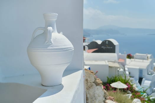 Greek island of Santorini, famous village Oia, closeup white clay amphora, copy space, background architecture and nature of island