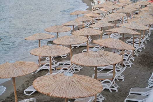 Greece Crete, Heraklion. 12-09-2019. Coast of Greek island Crete, empty sea beach with sun loungers and natural straw umbrellas, late evening after sunset, nobody