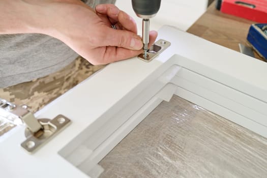 Furniture assembly. Closeup of workers hand with professional tools and furniture details