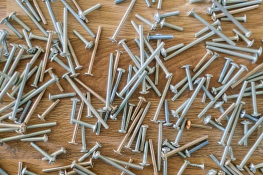 Chrome screws scattered on the floor, repair concept, furniture manufacturing. Abstract industrial background