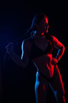 Young woman in underwear is in a studio with neon lights.