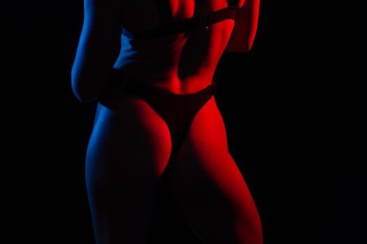 Young woman in underwear is in a studio with neon lights.